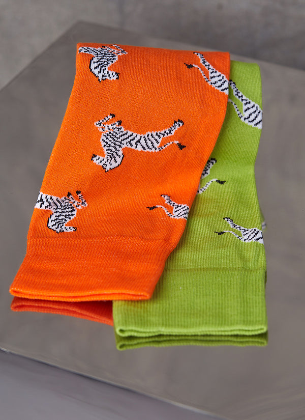 Group image of one pair of a large zebra sock in orange and another pair of a large zebra sock in lime green