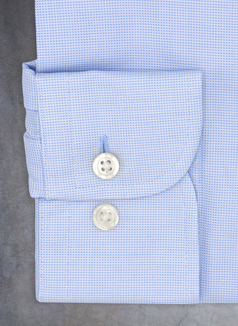cuff of light blue mini squares shirt with white buttons