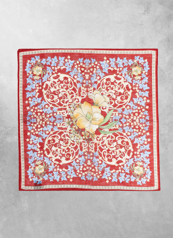 Decorative red scarf with floral and paisley patterns on a gray background