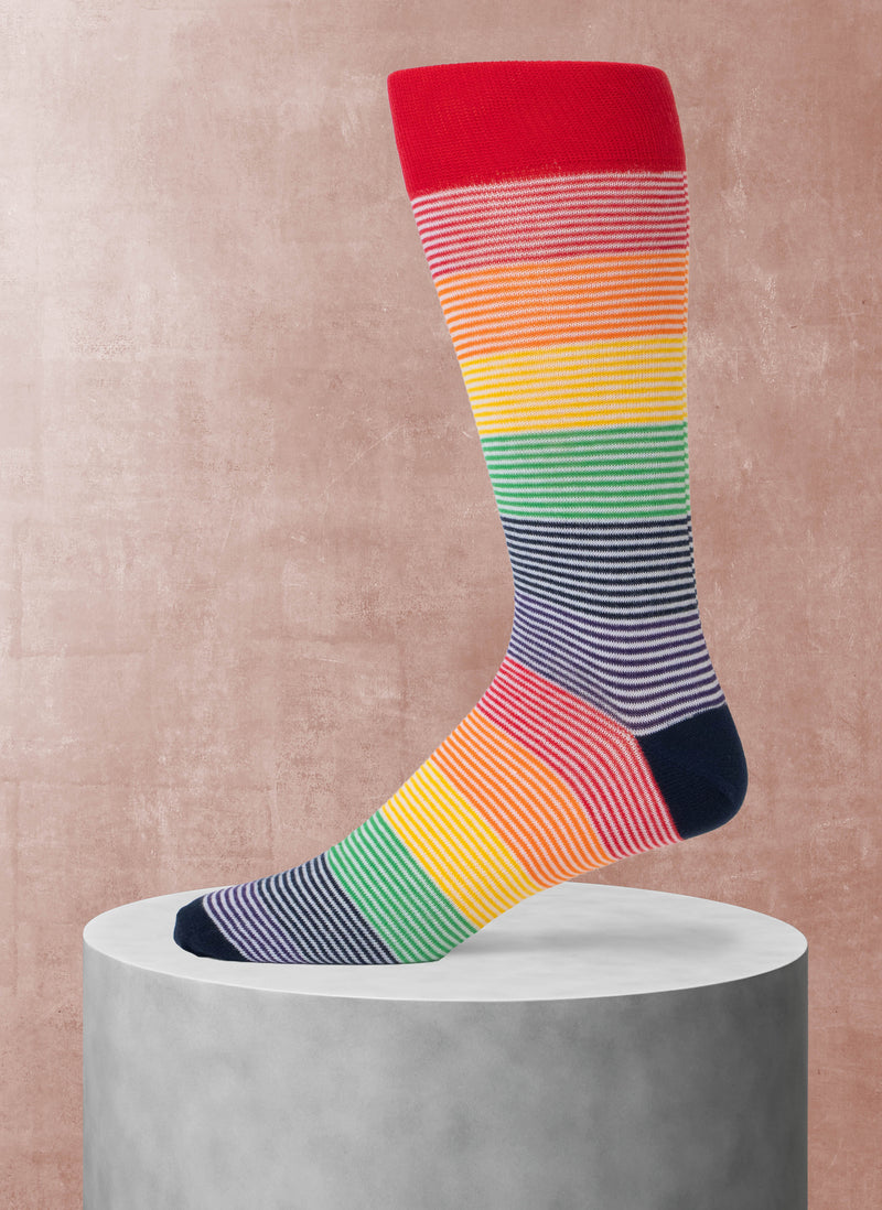 Colorful striped sock on a concrete block with a pinkish-beige background