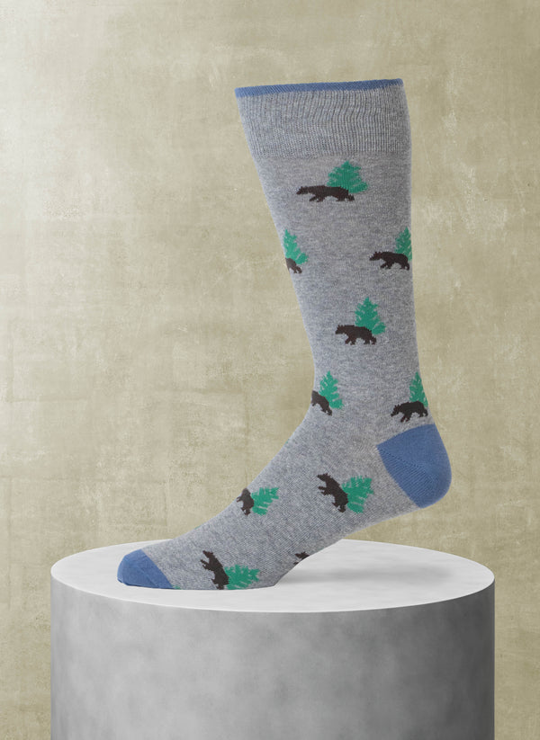 Gray sock with bear and pine tree pattern on a beige background