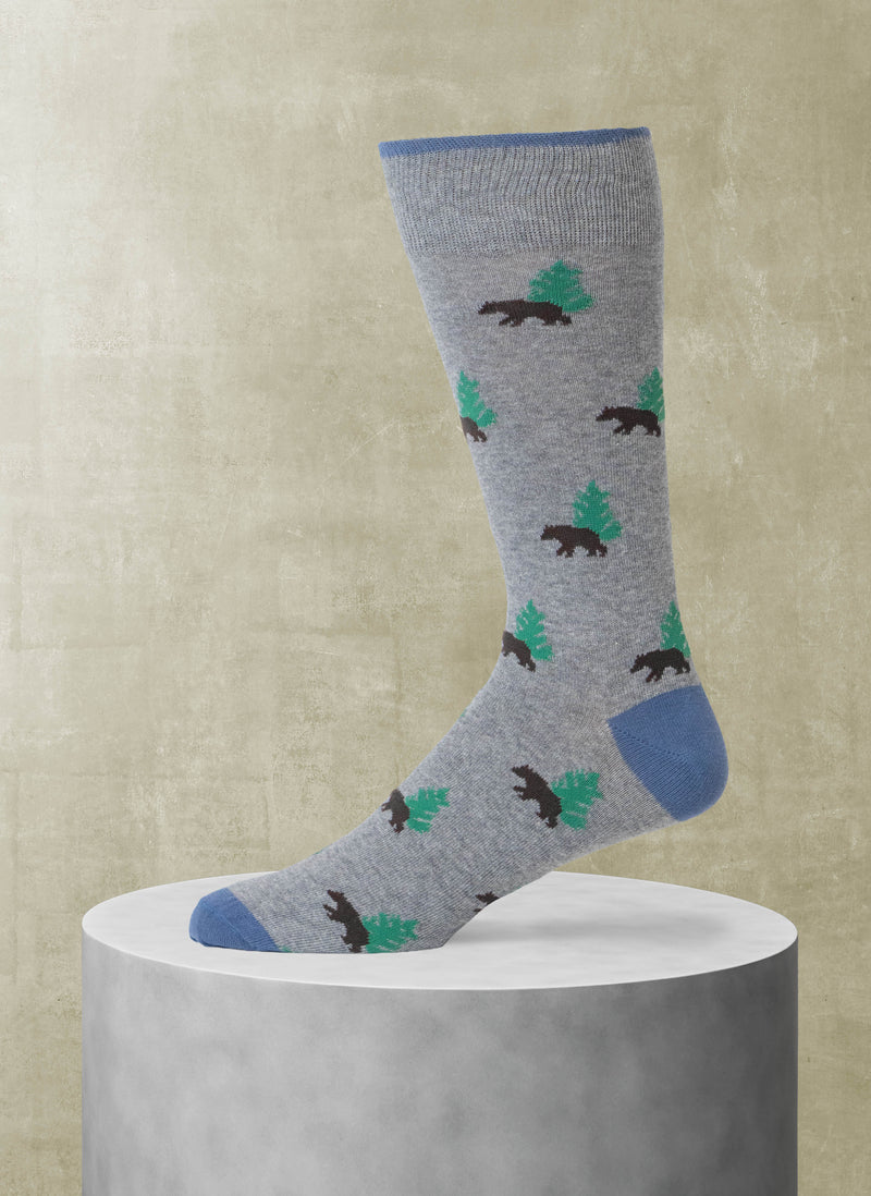 Gray sock with bear and pine tree pattern on a beige background
