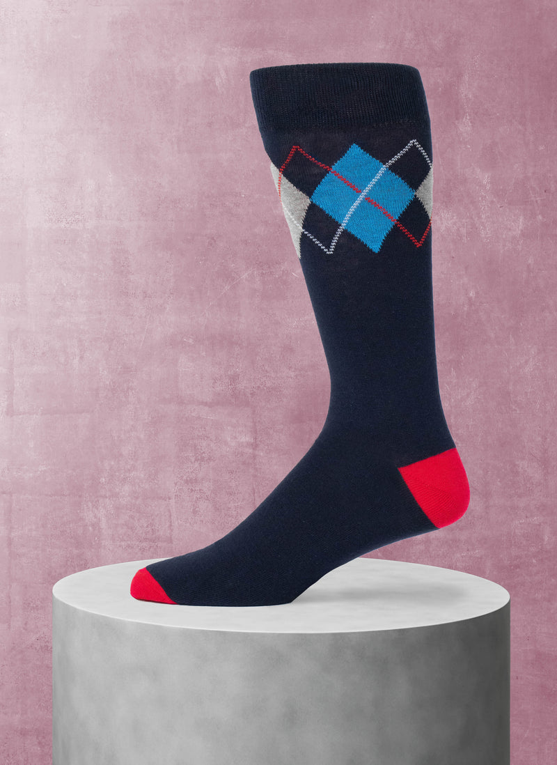 Navy sock with blue and red diamond pattern on a pink background