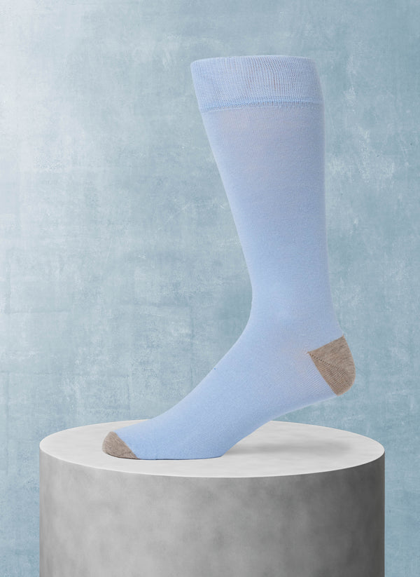Light blue sock on a gray pedestal against a light blue background