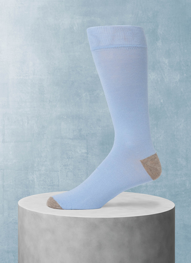 Light blue sock on a gray pedestal against a light blue background