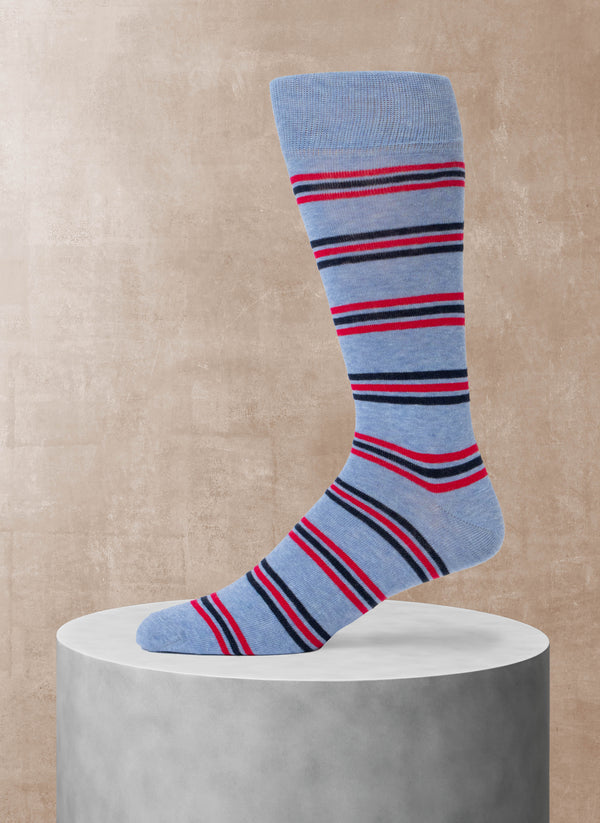 Blue sock with red and navy stripes on a beige background