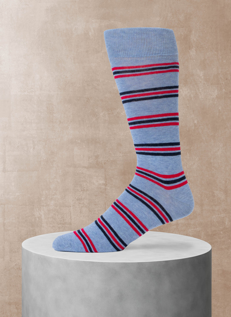 Blue sock with red and navy stripes on a beige background