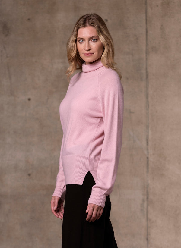 side image of Women's Cinzia Turtle Neck Cashmere Sweater in Light Pink featuring our luxurious cashmere wide leg pants in black 