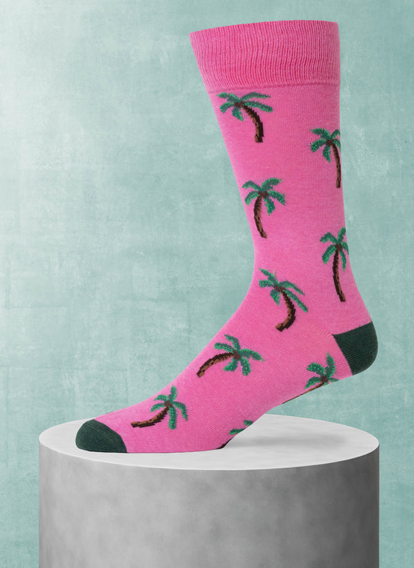 Pink sock with palm tree pattern on a light blue background