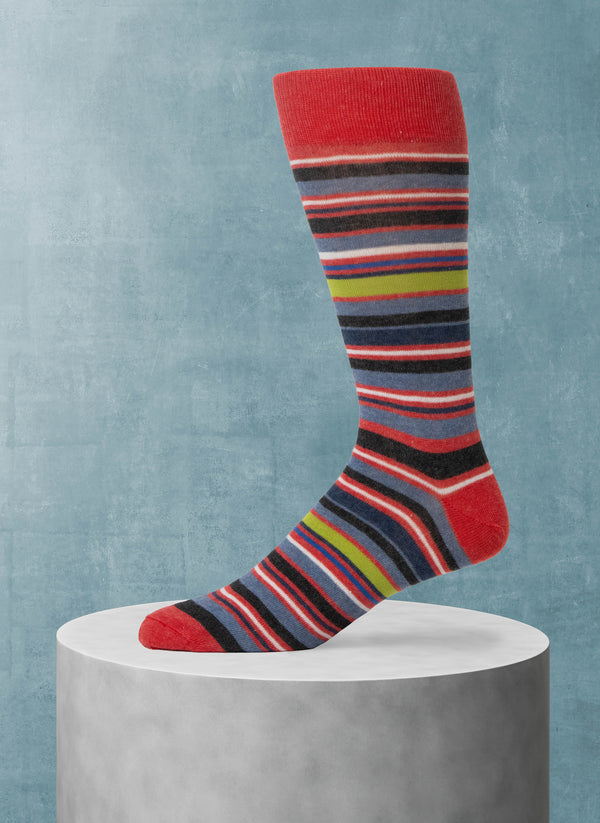 Colorful striped sock on a gray pedestal against a blue background