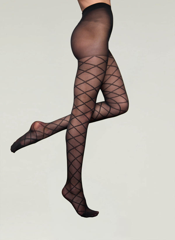 Black fishnet tights worn by a person on a plain background
