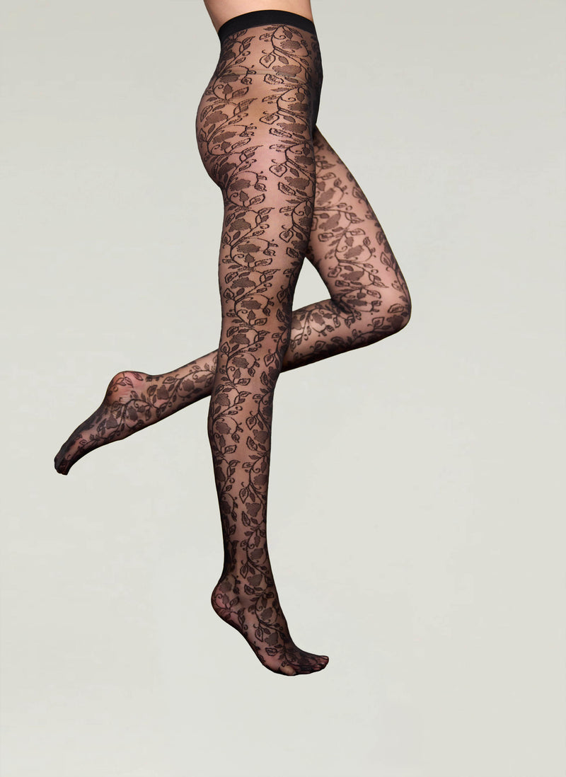 Black lace tights worn by a person on a light gray background