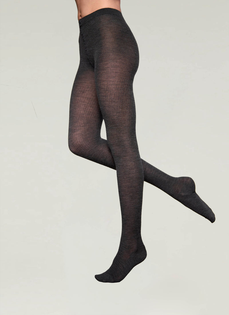 Black tights worn by a person on a light gray background