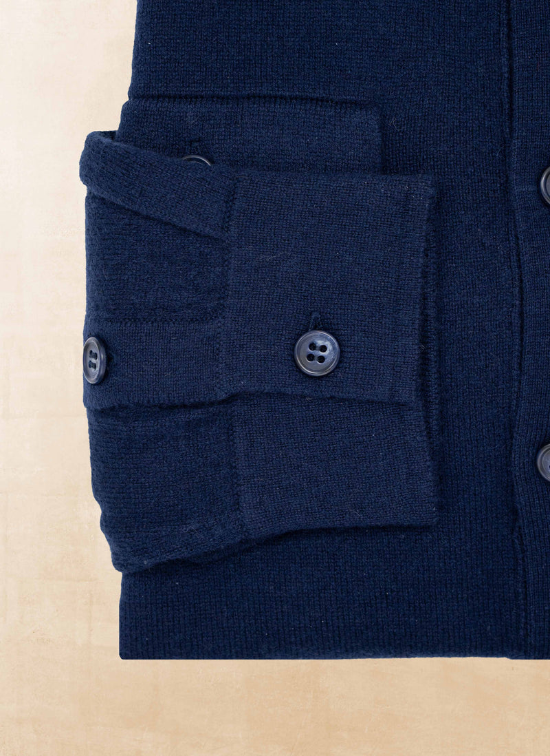 Close-up of a navy blue garment with button details on a beige background