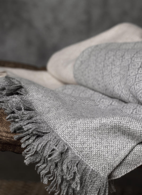 100% Cashmere Prato Throw with Fringe in Heather Grey Folded on Chair