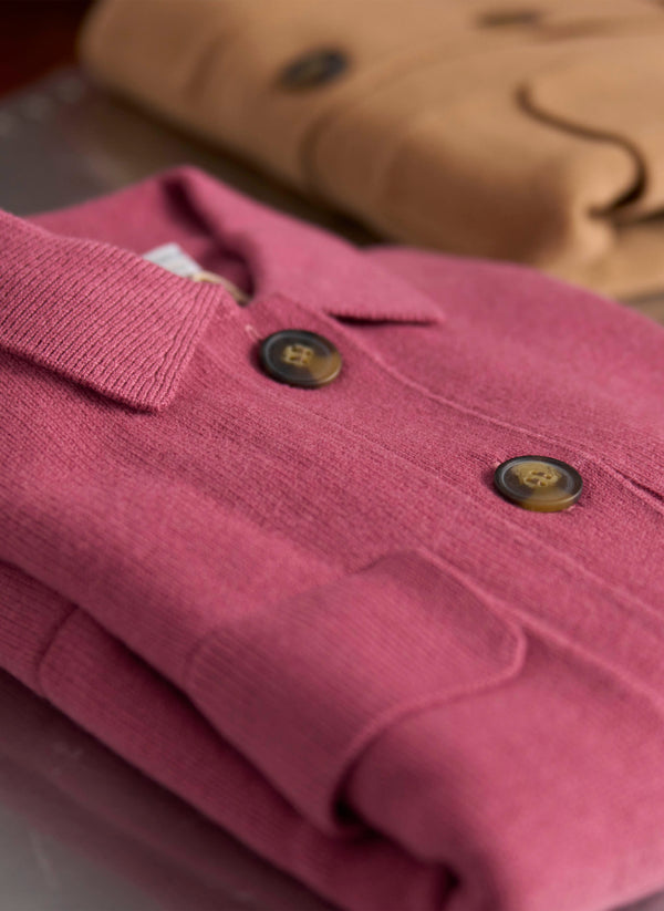 Close-up of a pink garment with buttons on a blurred background