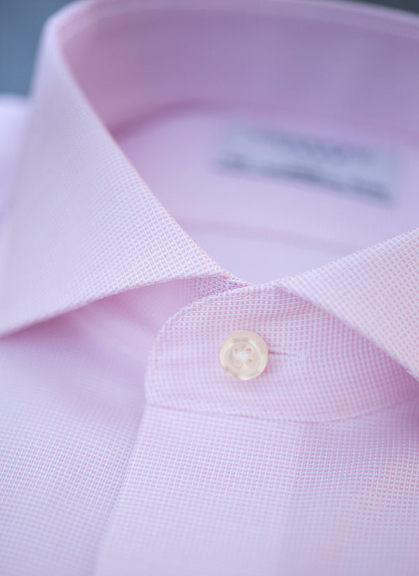 collar of solid pink textured shirt with white button