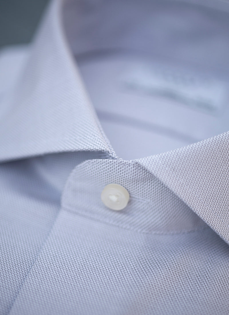 collar detail of solid textured grey shirt with white buttons