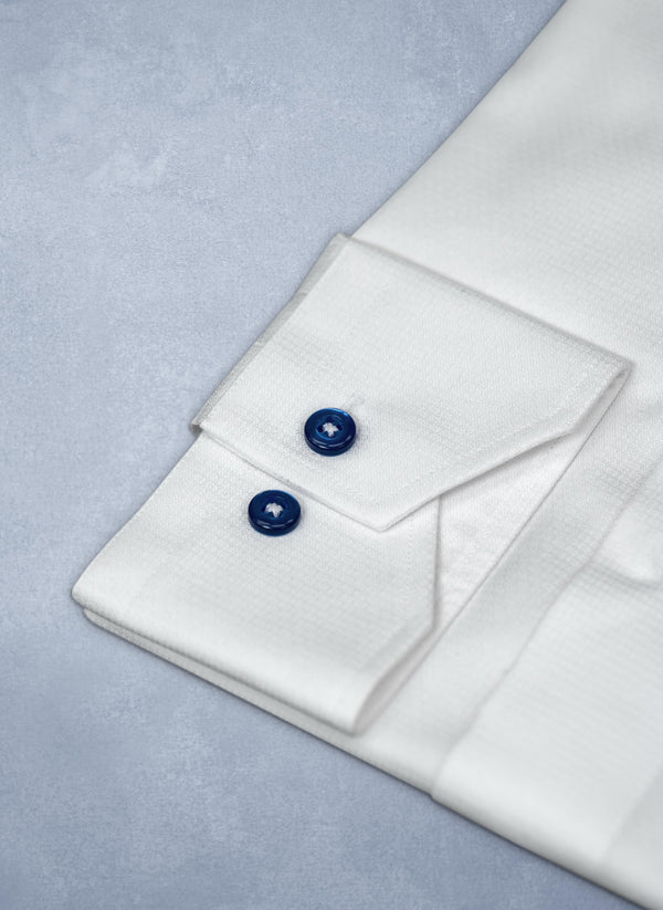 cuff detail of white dress shirt with navy buttons