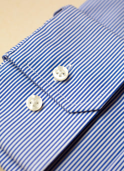 cuff detail of thin blue stripe dress shirt with white buttons