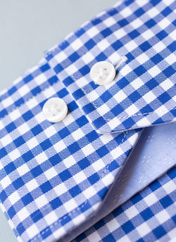 cuff detail of blue check shirt with white buttons