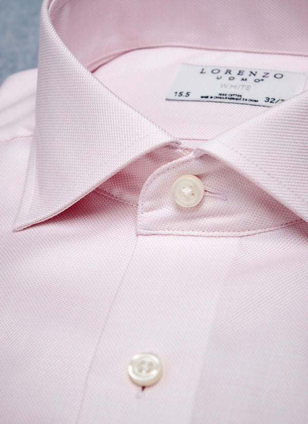 collar of solid textured pink shirt with white buttons