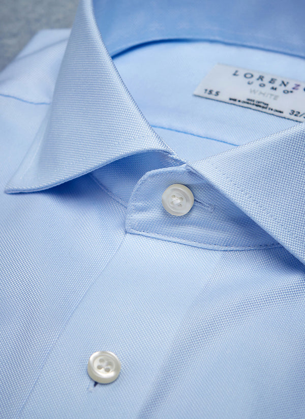 collar detail of solid blue basket weave shirt with white buttons and button thread with blue button hole