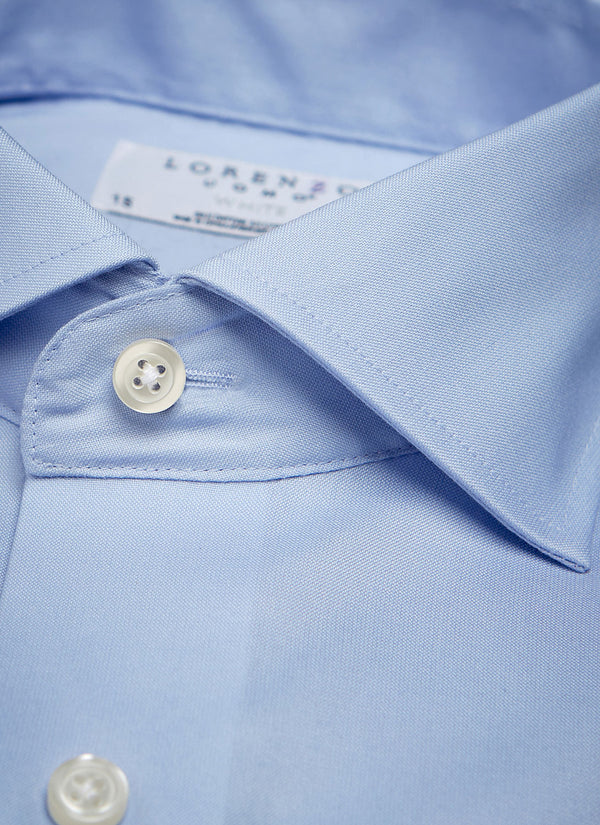 collar of light blue poplin shirt with white buttons and threads